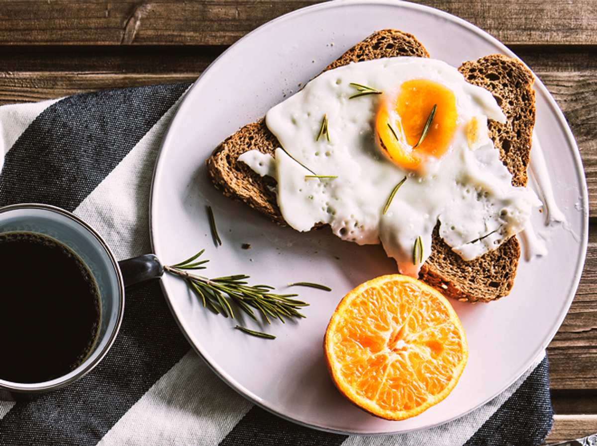 Eier, Zitrusfrucht, Brot und Kaffee