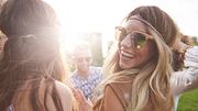 Frau mit Sonnenbrille tanzt mit Freunden und lacht in die Kamera. - Foto: gpointstudio/iStock (Themenbild)