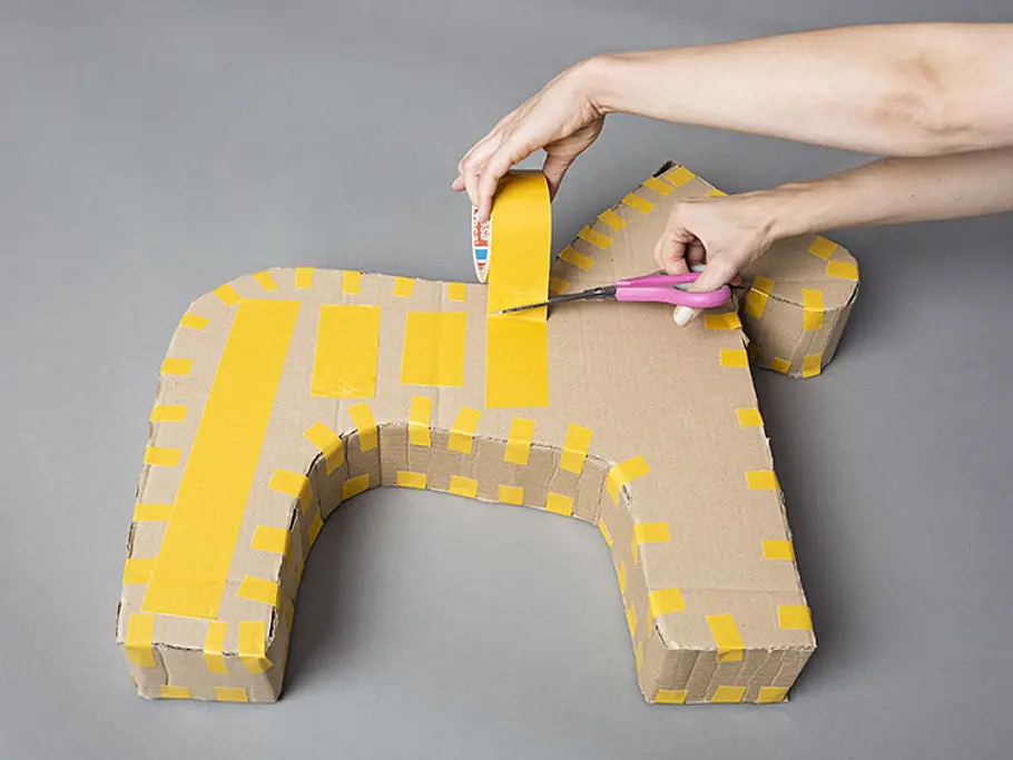 Anleitung für eine Einhorn-Pinata: Beklebe die Pinata mit doppelseitigem Klebeband