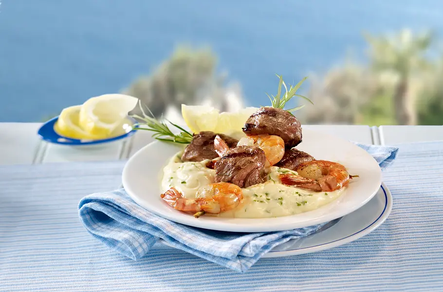 Eiweiß Rezept: Steak-Garnelen-Spieße mit Tofusoße Steak-Garnelen-Spieße mit cremiger Tofusoße auf einem weißen Teller.