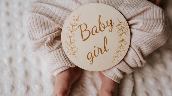 Babyfüße mit Schild, auf dem Babygirl steht (Themenbild) - Foto: TwentySeven/iStock