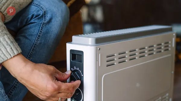 Eine Person dreht eine Elektroheizung auf - Foto: istock/ArtMarie