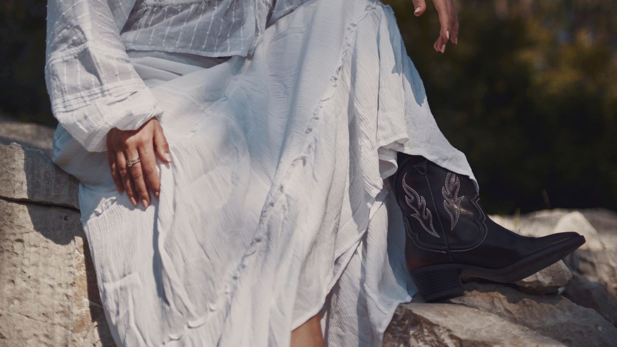 Flatterndes, weißes Kleid mit Cowboystiefeln