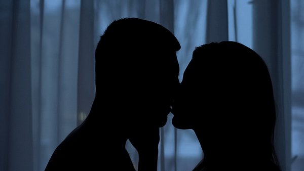 Mann und Frau küssen sich im Dunkeln - Foto: iStock/Motortion