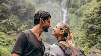 Ein heterosexuelles Paar, das sich liebevoll anschaut ist zusammen auf einer Wanderung. - Foto: Jacob Ammentorp Lund/iStock