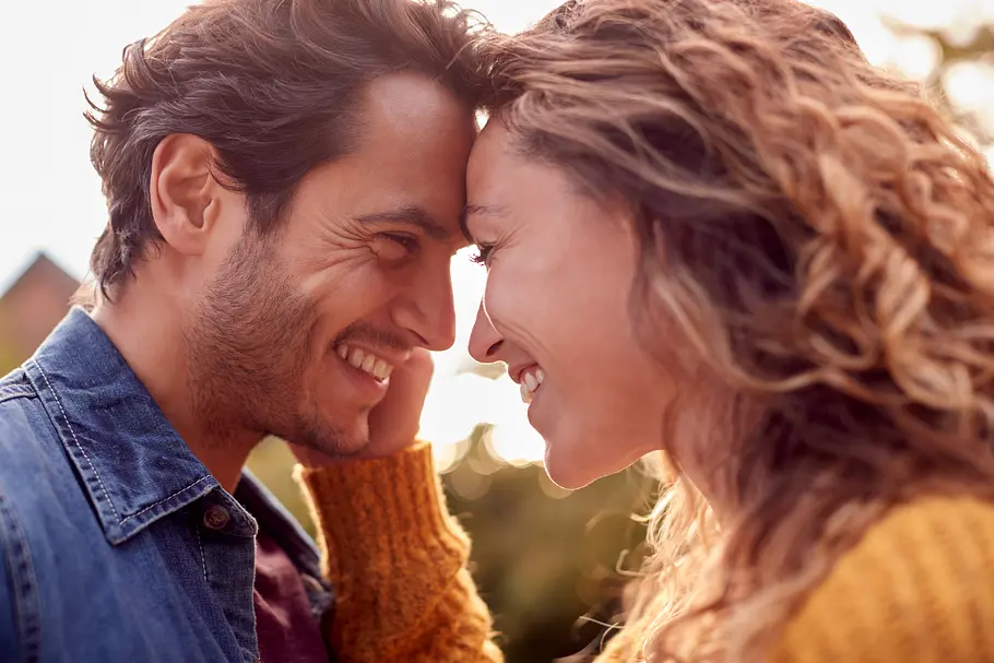 Erotische Liebesgeschichte Zwischen den Zeilen brennt es Paar teilt einen zärtlichen Moment, beide lachen.
