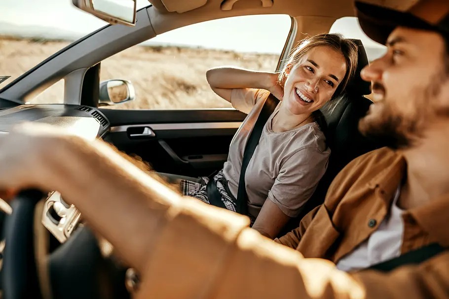 Erotische Liebesgeschichte: Probefahrt mit Nebenwirkungen Verliebtes Paar lacht und teilt einen zärtlichen Moment im Auto.