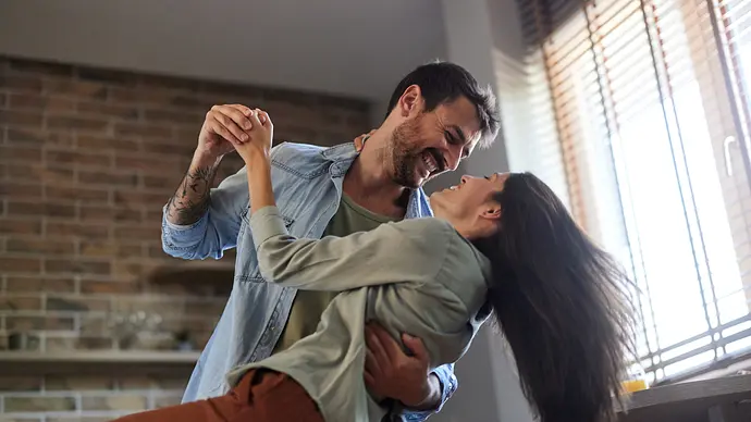 Verliebtes Paar tanzt zuhause lächelnd - Foto: iStock/skynesher