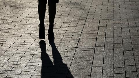 Schwarze Silhouette und Schatten einer einsamen Frau, die auf einer Straße hinabgeht - Foto: Oleg Elkov/iStock