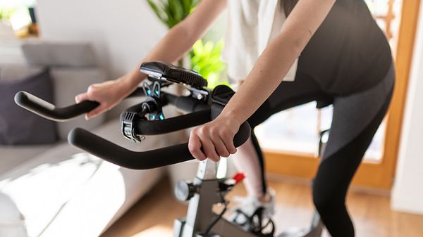 Frau trainiert auf einem Fahrradtrainer - Foto: iStock/SimonSkafar