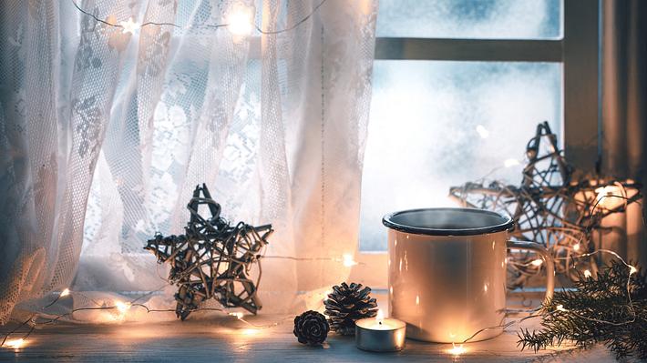 weihnachtlich dekoriertes Fenster mit Lichterkette - Foto: iStock/sofiaworld