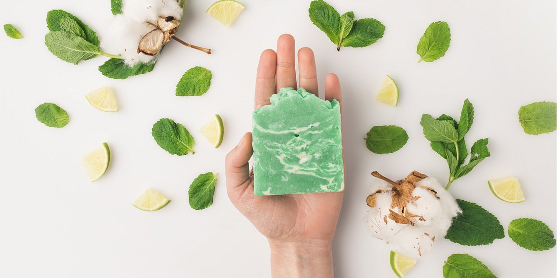 cropped shot of woman holding handcrafted soap on white surface