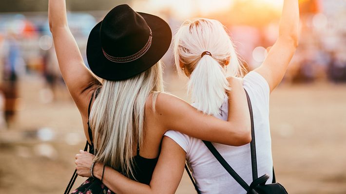 Zwei Frauen stehen mit dem Rücken zur Kamera nebeneinander und halten sich im Arm. - Foto: Astarot/iStock (Themenbild)