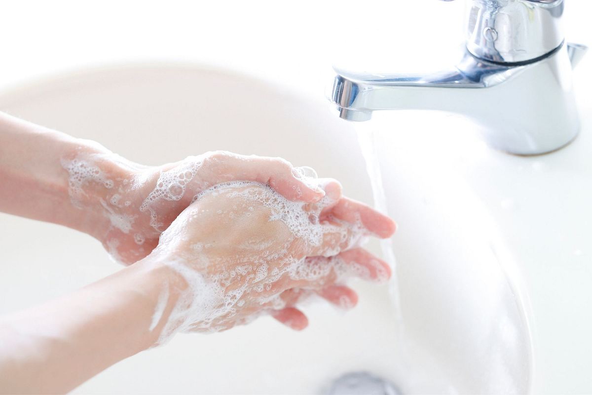 Frau wäscht sich Hände mit Seife.