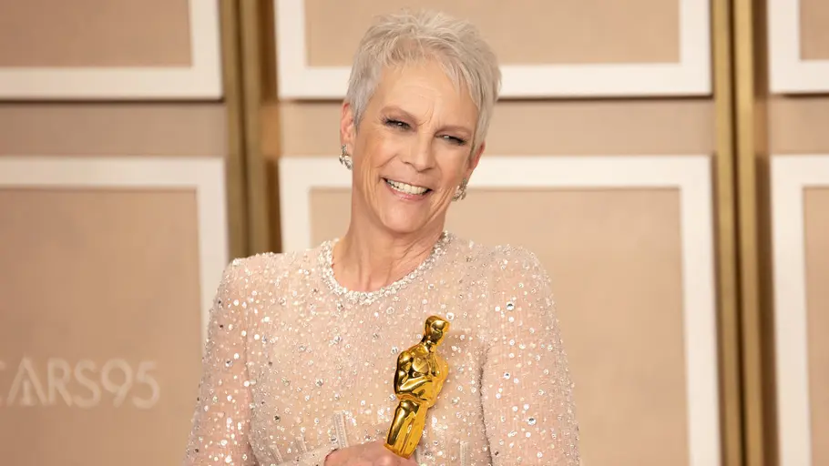Jamie Lee Curtis bei den Oscars mit Award und Glitzer-Oberteil, trägt Pixie