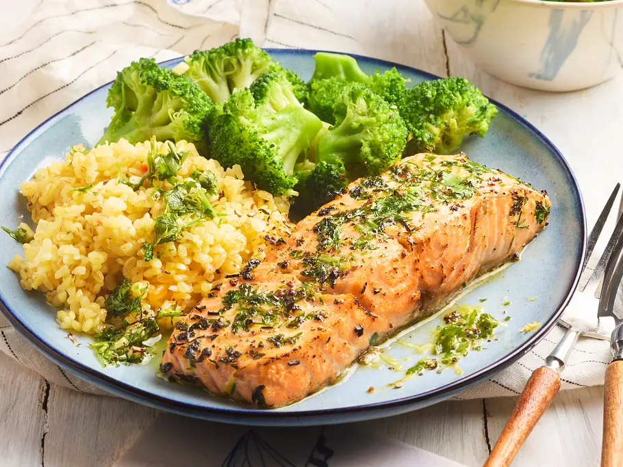 Lachsfilet auf einem Teller mit Bulgur und Brokkoli.