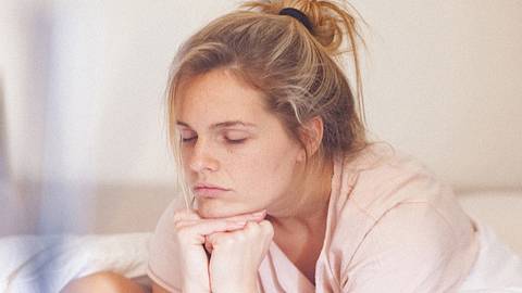 Eine Frau ist im Bett und müde (Themenbild) - Foto: gruizza/iStock