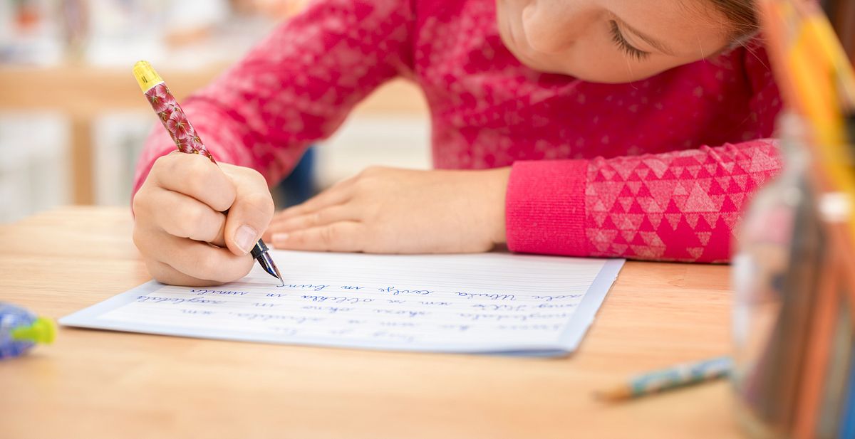 Schulkind schreibt mit Füller 