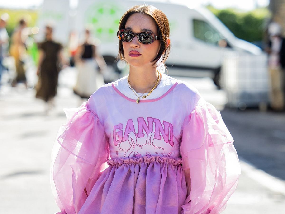 Frau in Tshirt mit Ganni Print und pinker Rüschen Bluse