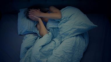 Frau im Bett kann nicht schlafen - Foto: janiecbros/iStock