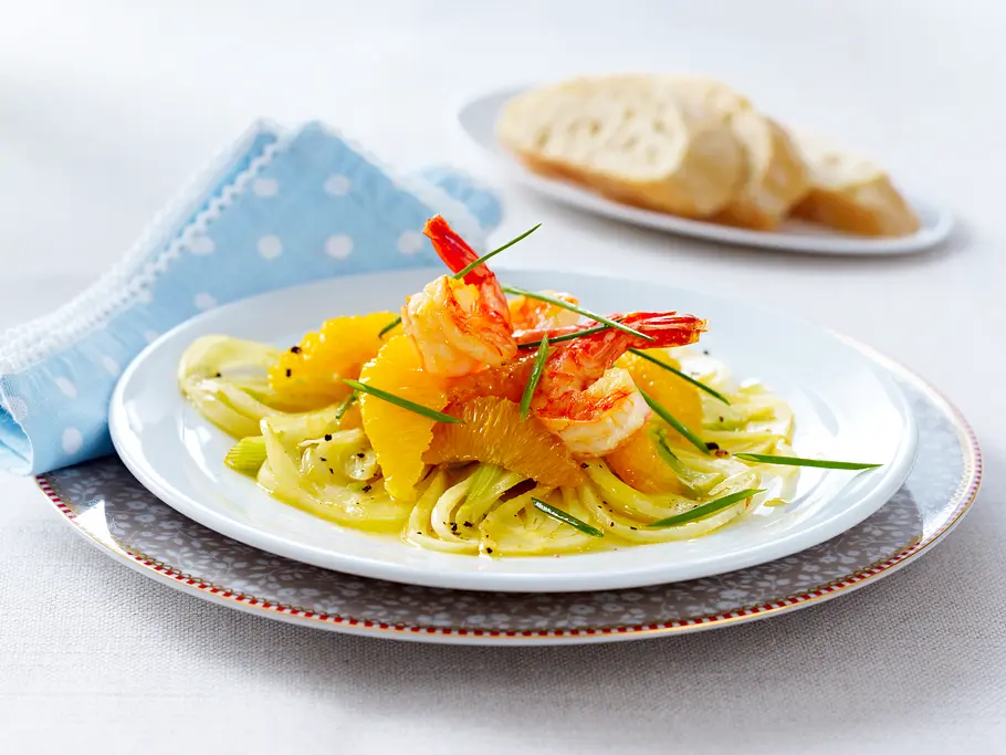 Garnelen-Gemüse: Ein Rezept mit viel Eiweiß Garnelen mit Orangenfilets auf Fenchelsalat. Im Hintergrund Baguettescheiben.