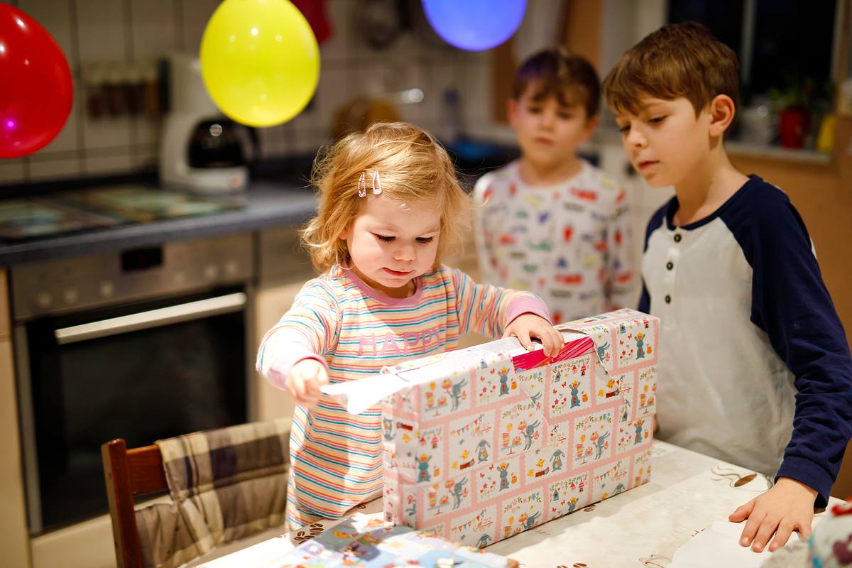 Eine 2-Jährige öffnet ihr Geschenk 