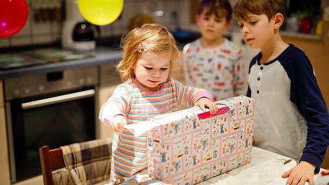 Eine 2-Jährige öffnet ihr Geschenk  - Foto: iStock / romrodinka