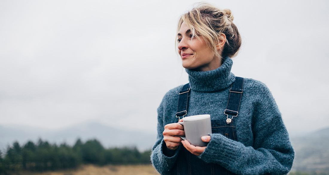 Frau trinkt eine Tasse Tee in der Natur
