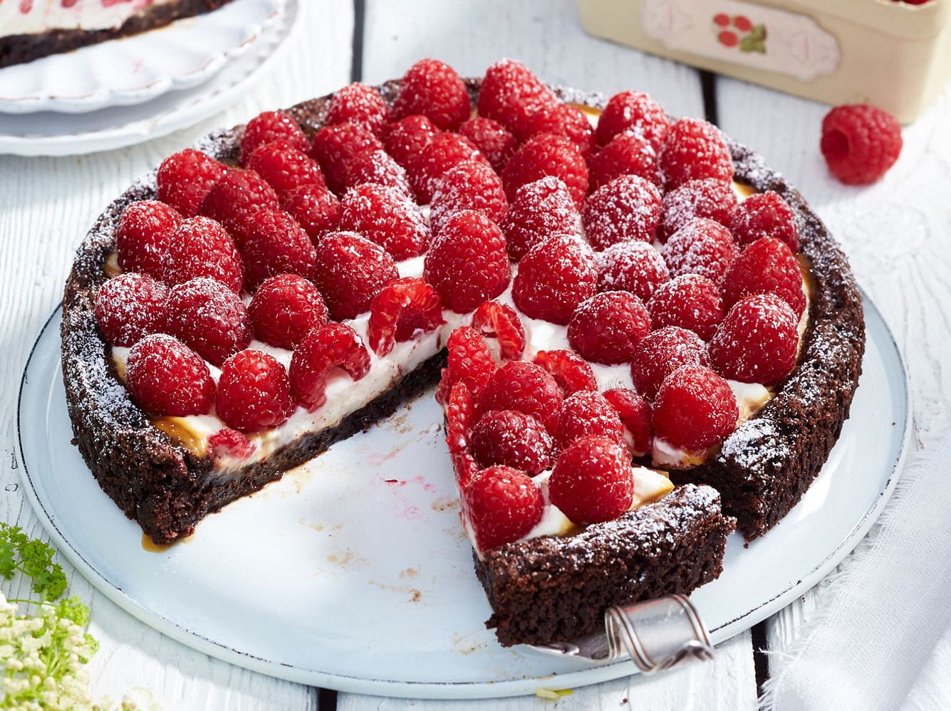 Schokoladiger Boden trifft auf Karamell mit Schmandcreme und fruchtigen Himbeeren.