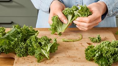 Weibliche Hände, die frischen Grünkohl vorbereiten. - Foto: House of Food / Bauer Food Experts KG