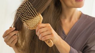 Haarbürste ohne Ziepen an einer Frau - Foto: iStock / CentralITAlliance 