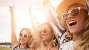 Drei Frauen mit Sonnenbrille haben ihren Spaß auf einem Festival.  - Foto: gpointstudio/iStock (Themenbild)