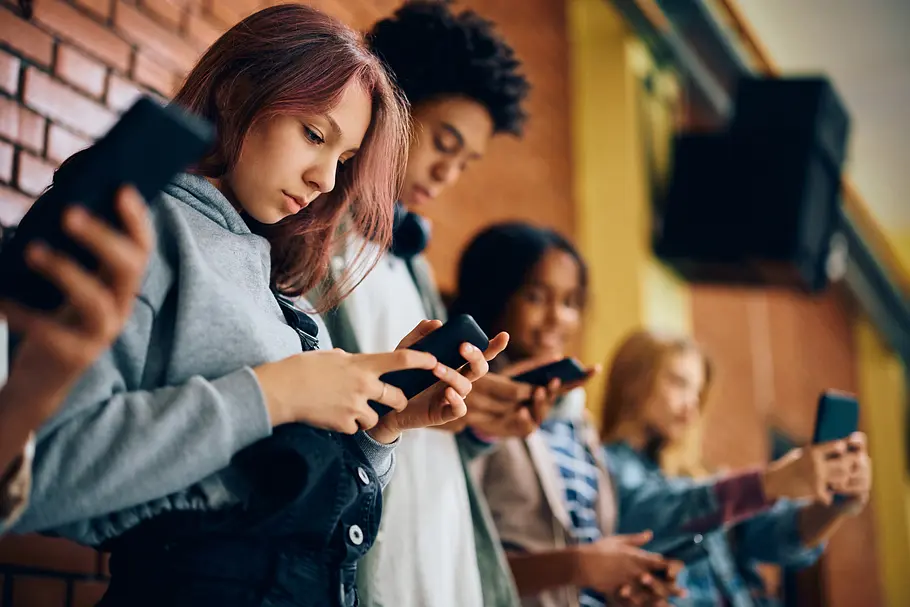 Schülerinnen und Schüler in der Schule auf dem Pausenflur mit Handy Schülerinnen und Schüler in der Schule auf dem Pausenflur mit Handy