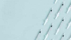 Syringe pattern on blue background with copy space. - Foto: Selcuk1/iStock