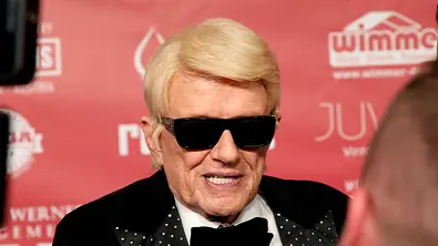 Schlagersänger Heino mit schwarzer Sonnenbrille und Fliege bei einem öffentlichen Auftritt auf dem roten Teppich. - Foto: IMAGO / Future Image