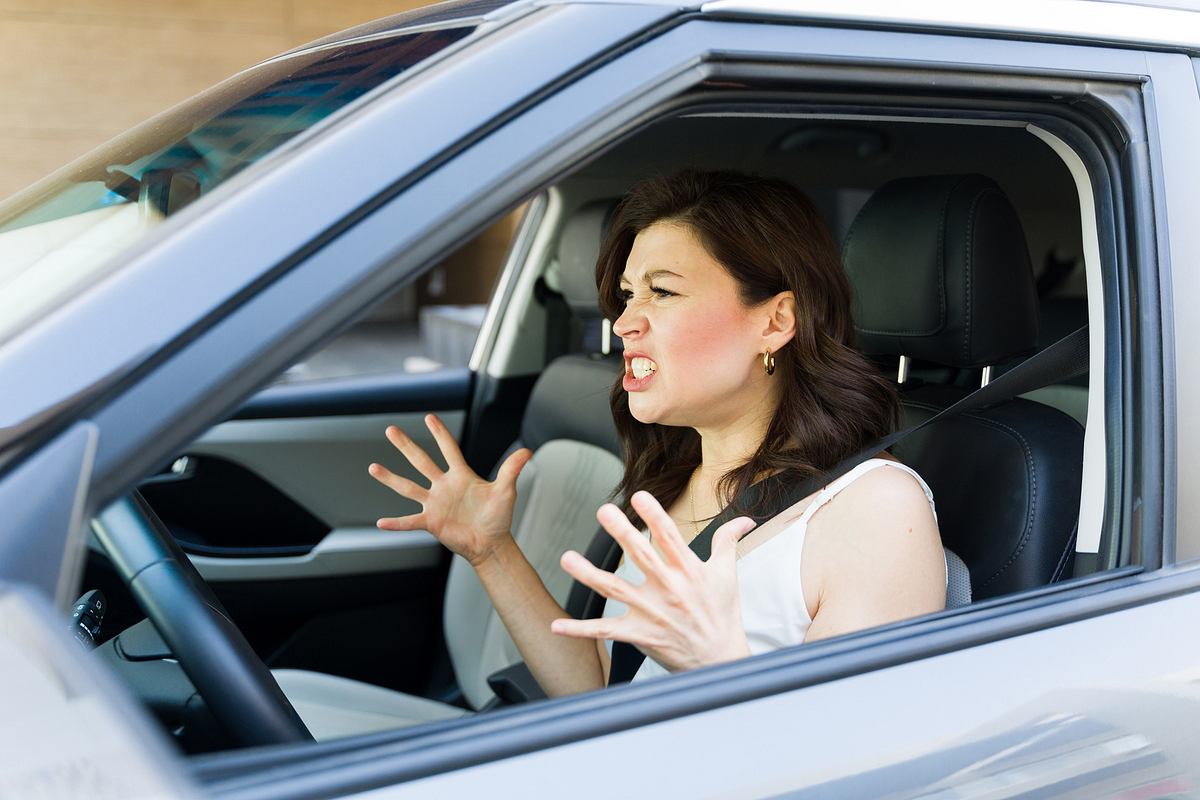 Frau bei Hitze im Auto, die wütend wird.