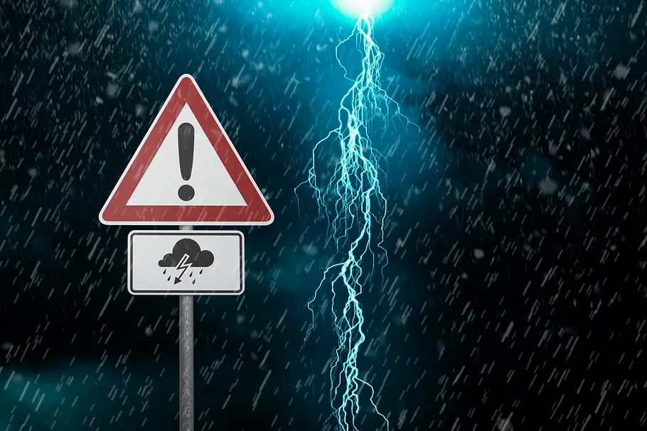 Hitzewelle endet mit lautem Knall! Hier wird es besonders schlimm Ein dunkler bewölkter Himmel mit Regen, Blitzen und einem Achtung-Warnzeichen. Symbolbild für Gewitter und Unwetterwarnung.