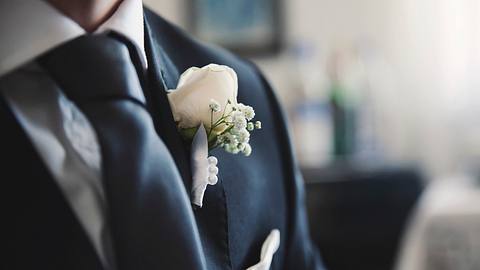 Hochzeitsanzug mit weißer Ansteckrose - Foto: iStock
