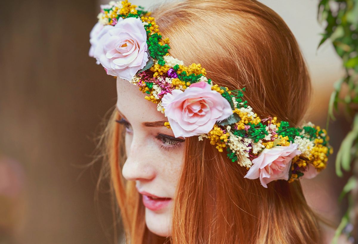 Frau mit offenen langen roten Haaren und einem Blumenkranz