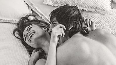 Frau und Mann liegen zusammen im Bett und lachen. - Foto: iStock/oleg66