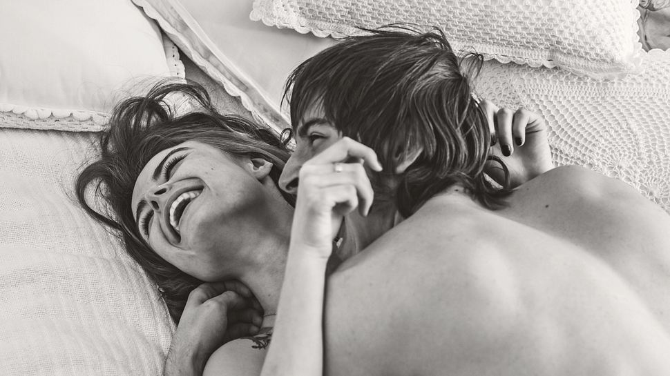 Frau und Mann liegen zusammen im Bett und lachen. - Foto: iStock/oleg66