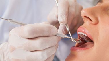 Nahaufnahme: Zahnarzt untersucht Zähne eines Patienten im Zahnärzte Stuhl. - Foto: :Wavebreakmedia/iStock