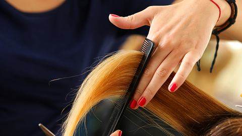 Langes blondes Haar wird beim Friseur geschnitten (Themenbild) - Foto: istock/megaflopp