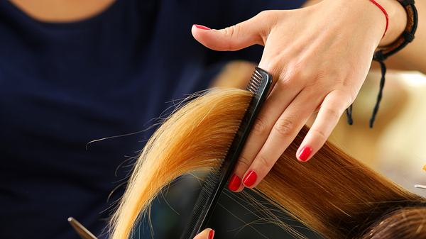 Langes blondes Haar wird beim Friseur geschnitten (Themenbild) - Foto: istock/megaflopp