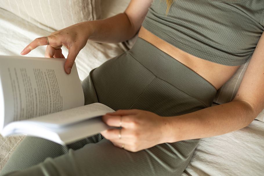 Frau auf dem Sofa, mit Buch in der Hand