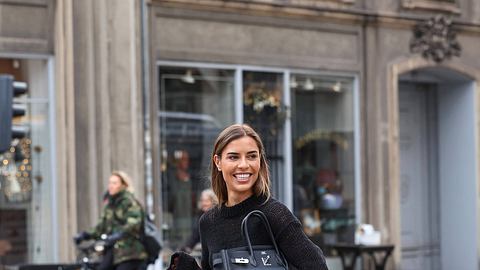 Freu mit schwarzem Oberteil und Tasche unter dem Arm - Foto: IMAGO/  ZUMA Press Wire