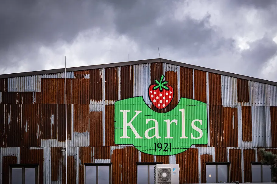 Karls Erdbeerhof: Scheue mit Firmenlogo und dunklen Wolken im Hintergrund Karls Erdbeerhof: Scheue mit Firmenlogo und dunklen Wolken im Hintergrund