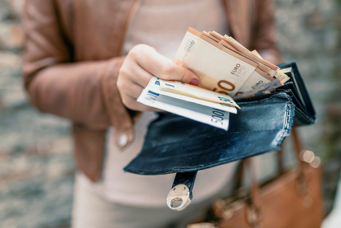 Frau hält in Händen Brieftasche mit Euro Geld.