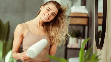 Ionen-Haartrockner: Eine Frau trocknet ihre langen nassen Haare mit einem Föhn - Foto: iStock/ Mariia Vitkovska Ionen-Haartrockner: Eine Frau trocknet ihre langen nassen Haare mit einem Föhn - Foto: iStock/ Mariia Vitkovska