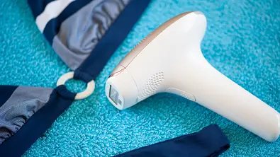 IPL-Gerät und Bikini auf einem Handtuch - Foto: iStock/ Julia_Albul